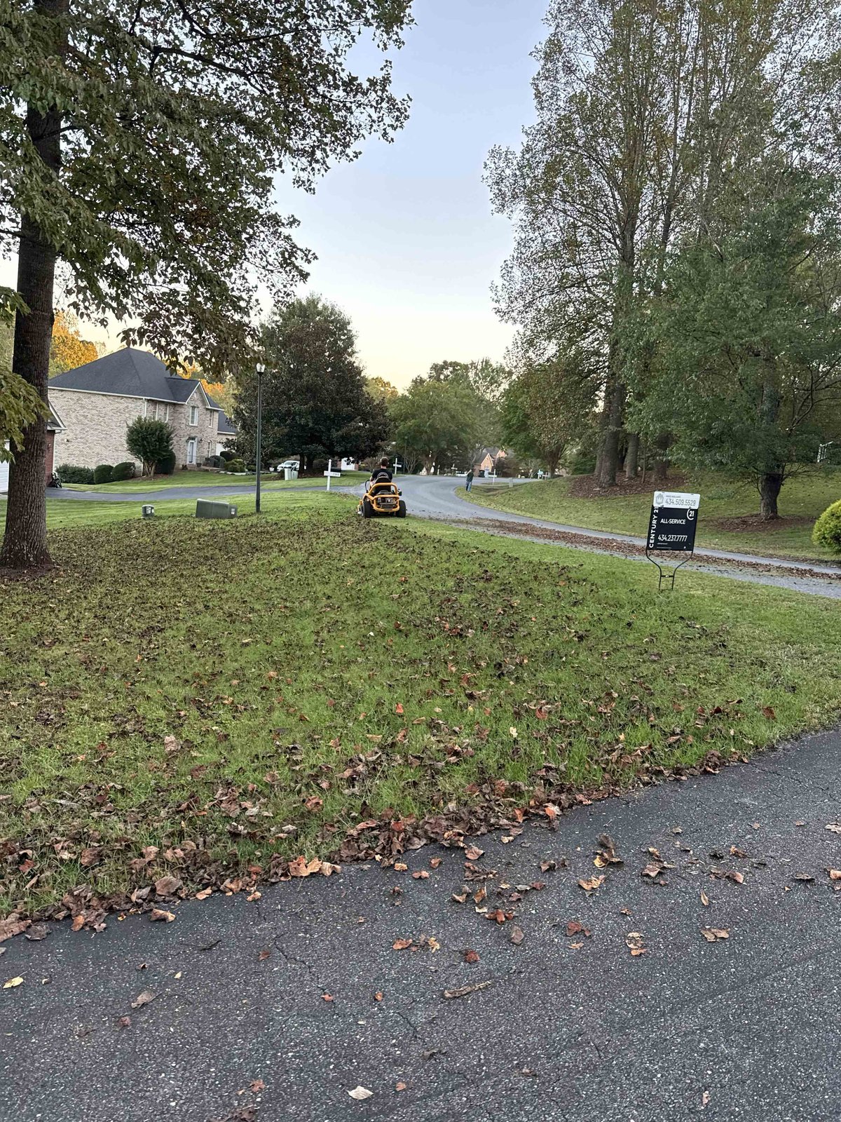 Riding mower cutting a leaf-covered lawn on a property near Lynchburg, VA in autumn